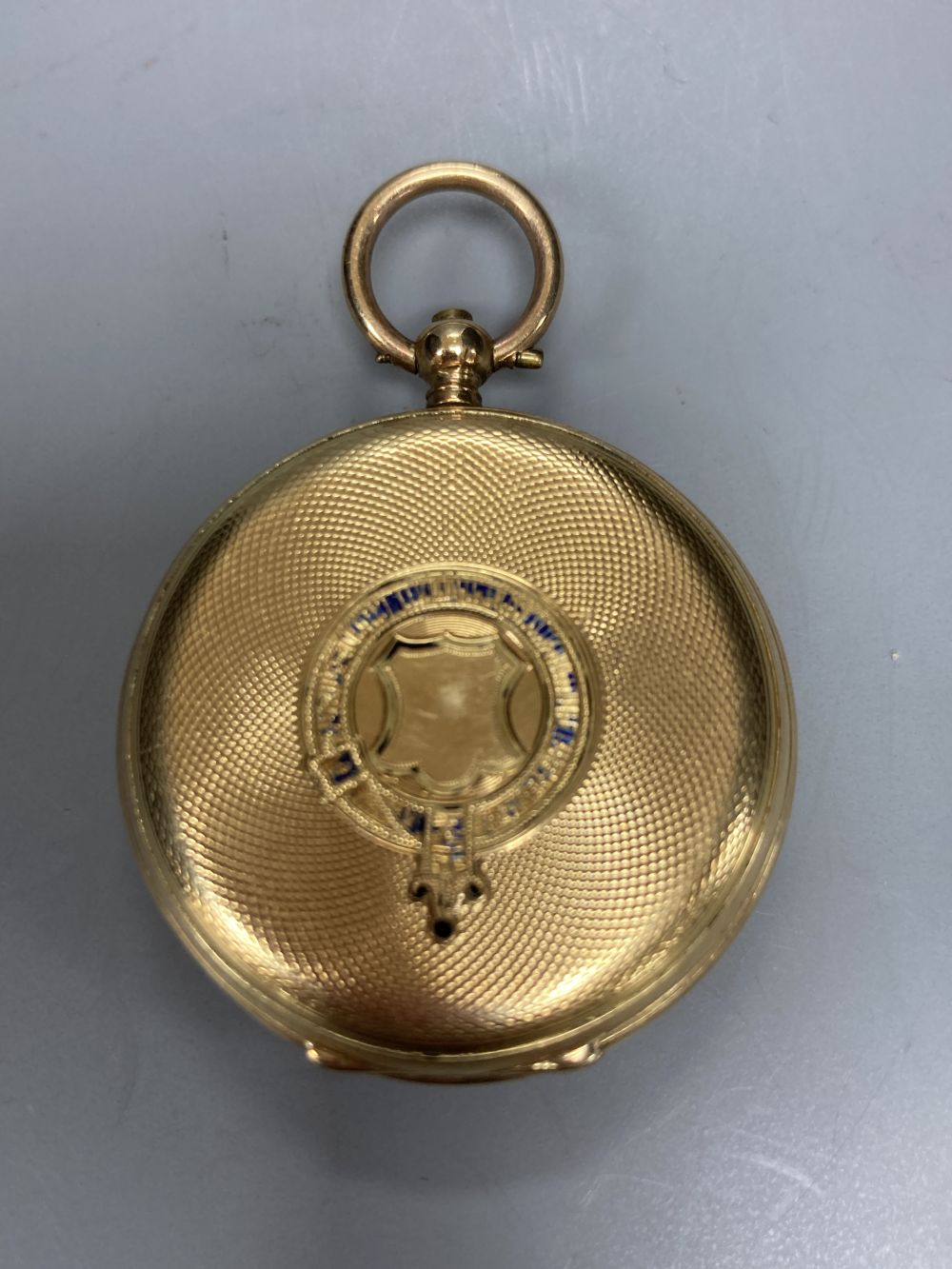 An early 20th century engine turned 18k and enamel(a.f.) keywind fob watch, case diameter 35mm, gross 29.2 grams.